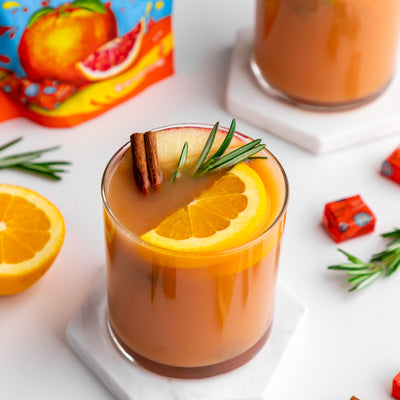 Thanksgiving Punch on white countertop with garnishes and Chewie Fruities organic candy
