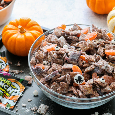 Sour Punch Halloween Muddy Buddies next to mini pumpkins