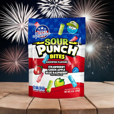 Bag of Sour Punch Assorted Americana Candy Bites on a picnic table with fireworks in the background