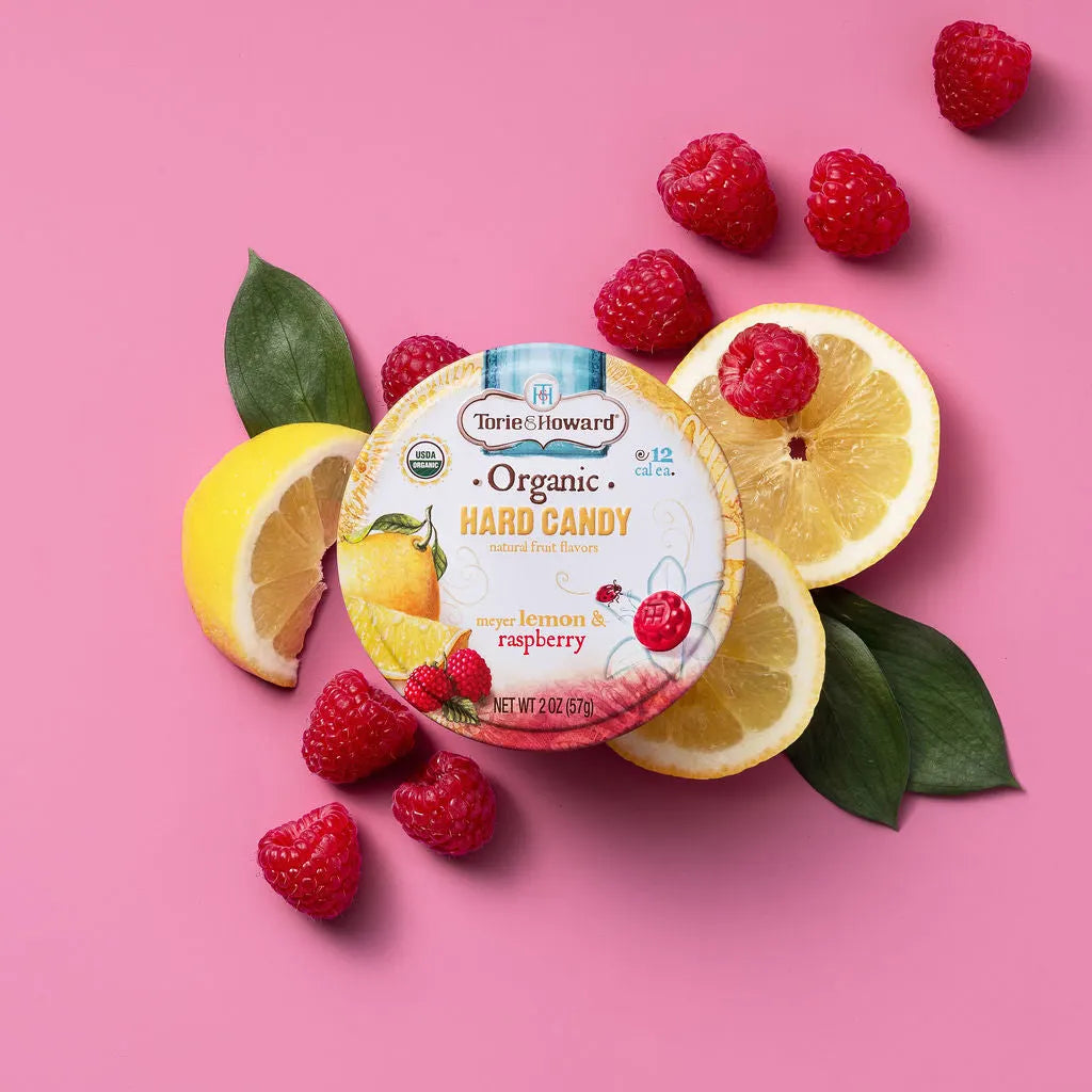 Torie & Howard Meyer Lemon & Raspberry Organic Hard Candy 2oz Tin on fresh raspberries and sliced lemons