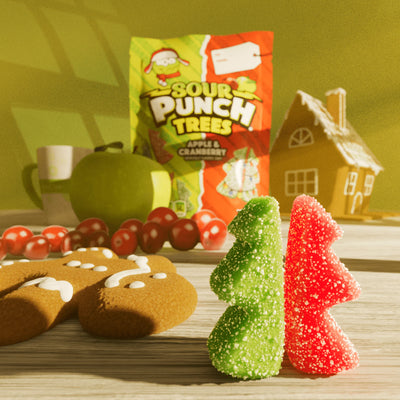 Sour Punch Trees candy and gingerbread cookies on a table with a green background