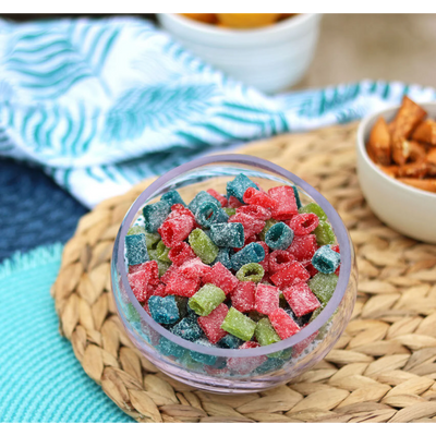 Bowl of Sour Punch Assorted Mini candy on a beach blanket with other salty snacks