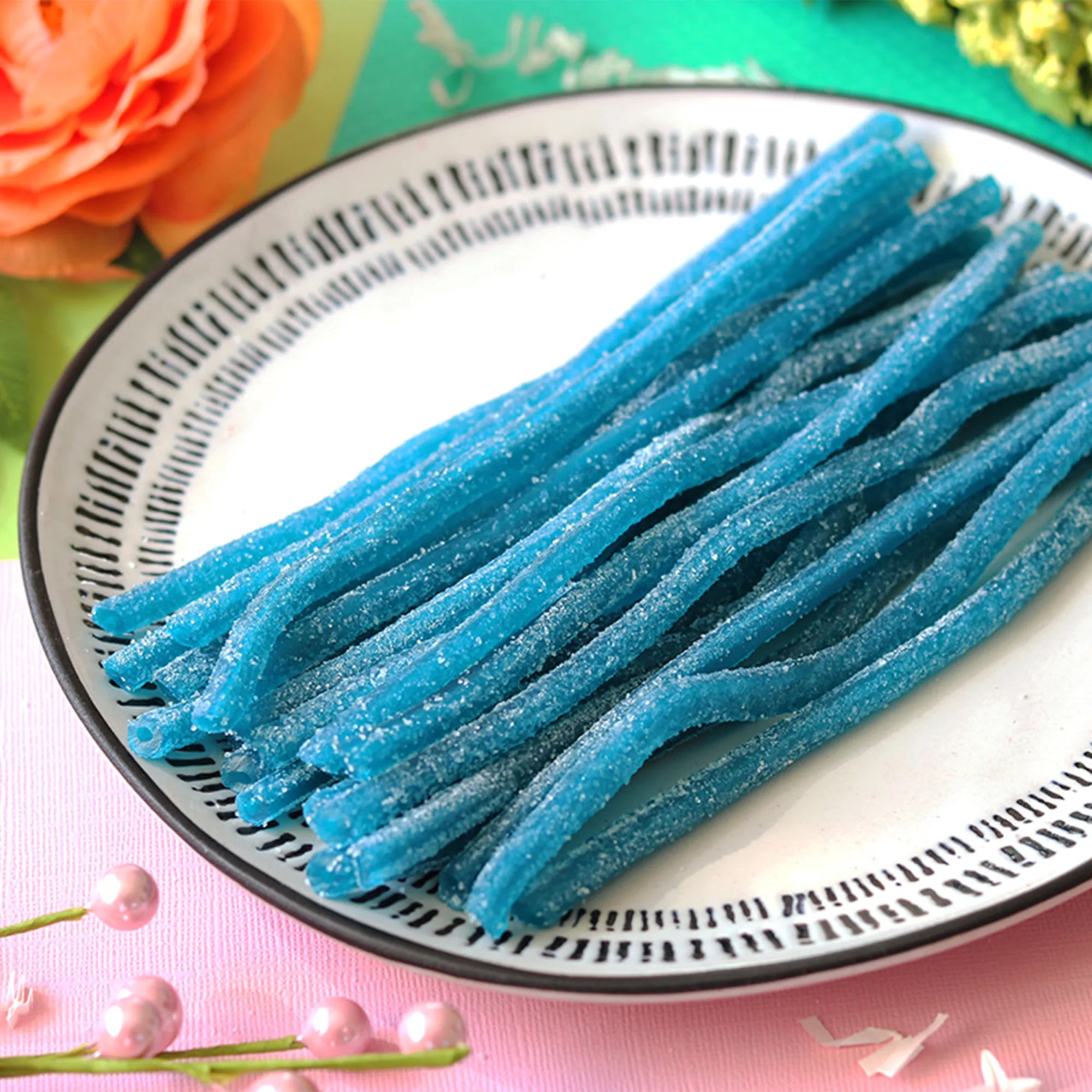 Blue Raspberry Strawberry Straws candy in a pastel colored spring scene