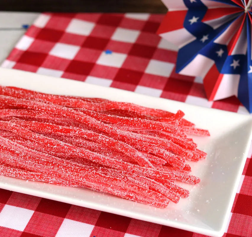 Sour Punch Strawberry Straws Candy on a picnic table with patriotic decorations