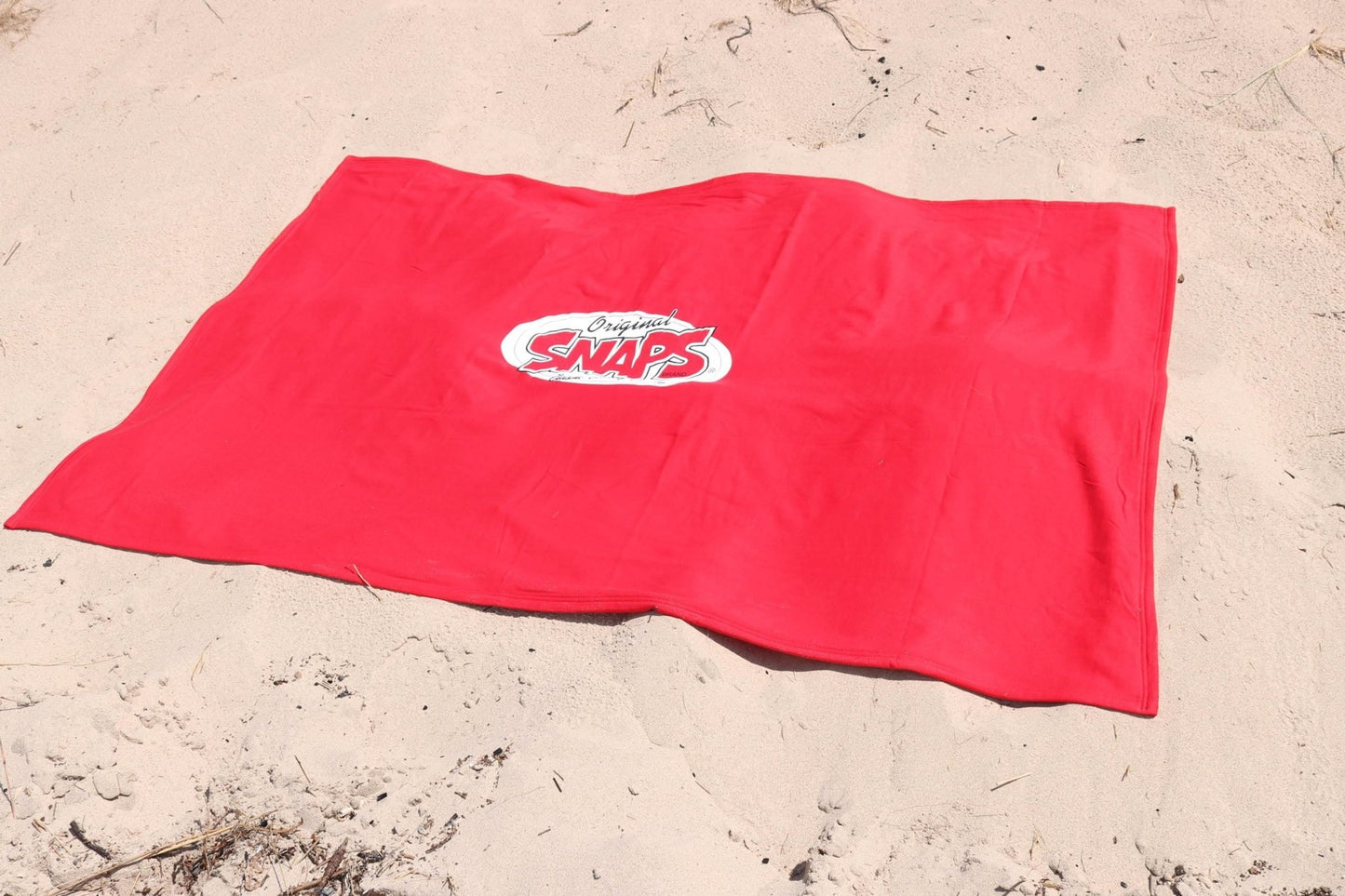 SNAPS Blanket laying on a beach SNAPS Blanket laying on a beach