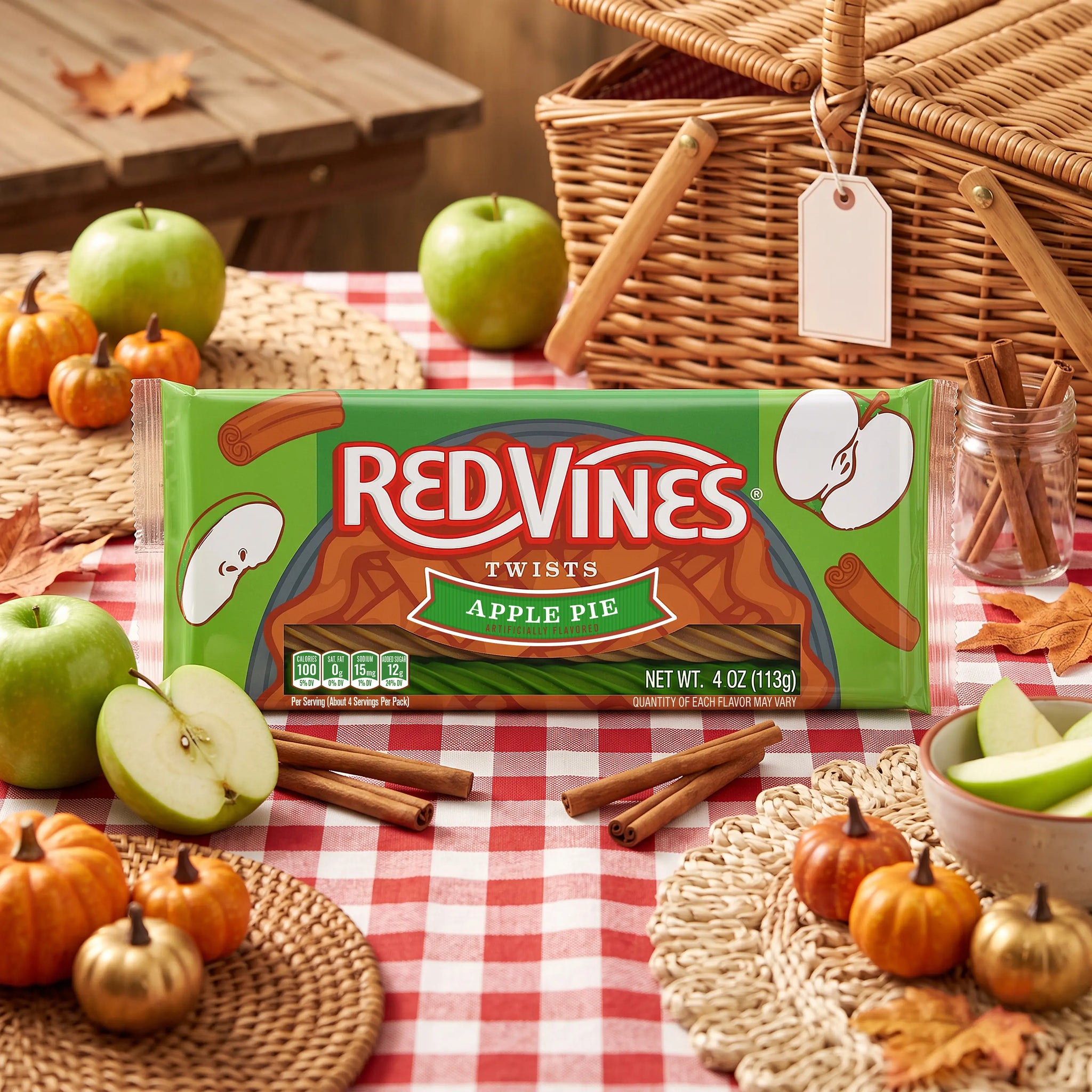 Red Vines Apple Pie Twists on a fall-themed picnic table with apples and pumpkins and cinnamon sticks
