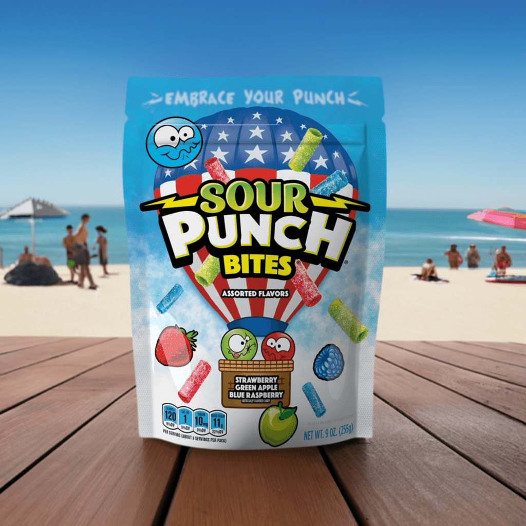 Share size bag of Sour Punch Assorted Americana Bites on a picnic table at the beach