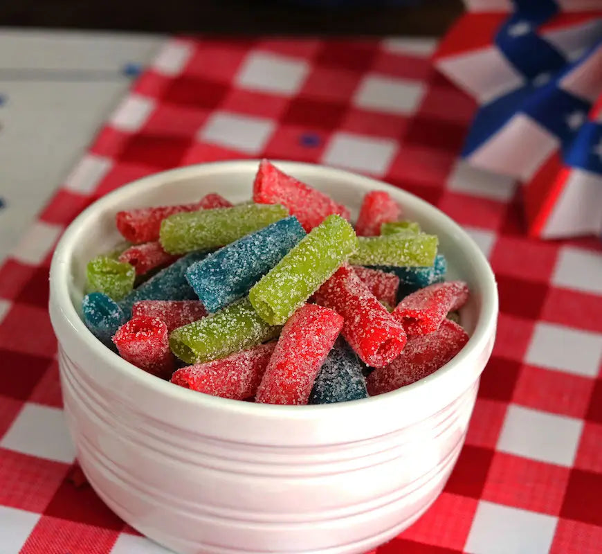 Sour Punch Assorted Candy Bites summer candy in a bowl on top of an Americana-themed picnic table  