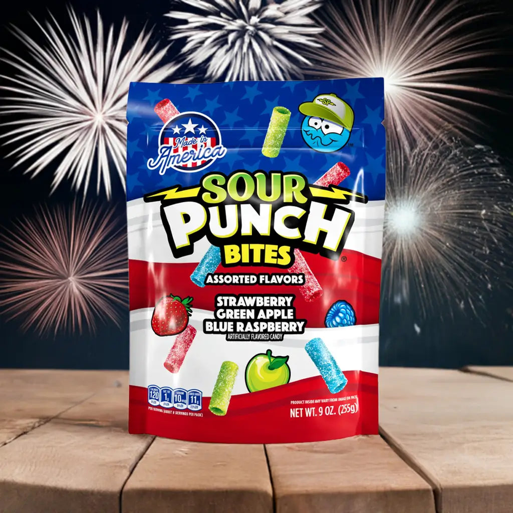 Bag of Sour Punch Assorted Americana Candy Bites on a picnic table with fireworks in the background