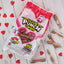 SOUR PUNCH Valentine Candy Twists on a table with red paper hearts