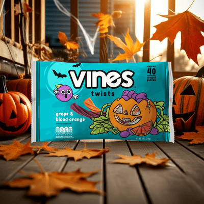 Vines twists packaging with Halloween-themed design on a wooden surface with pumpkins and leaves.