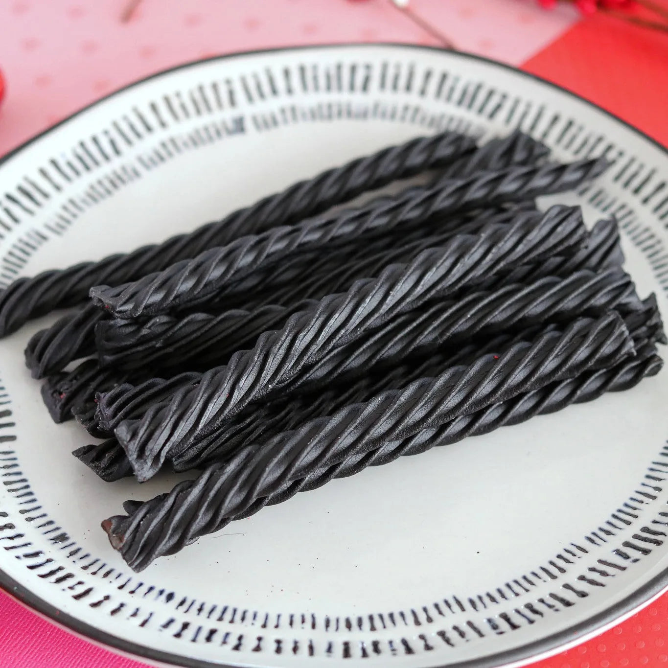 RED VINES Black Licorice Twists on a white plate surrounded by valentine decor