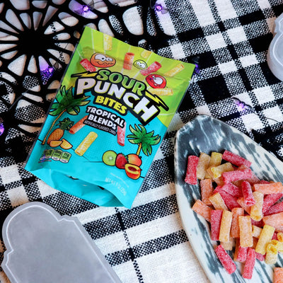 Sour Punch Tropical Bites Candy on a platter with a fake spiderweb and tombstone
