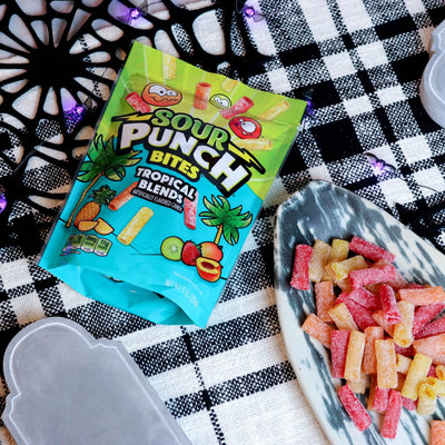 Sour Punch Tropical Bites Candy on a platter with a fake spiderweb and tombstone