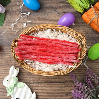 Sour Punch Strawberry Straws candy in an Easter basket  surrounded by confetti and plastic eggs