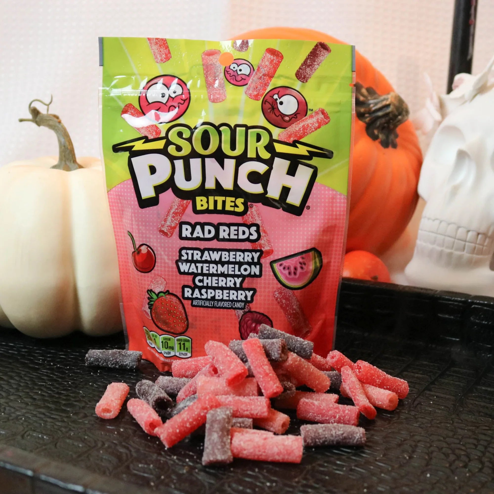 Sour Punch Rad Red Bites Candy on a black tray with pumpkins and fake skulls