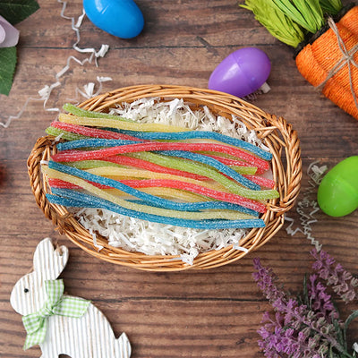 Sour Punch Rainbow Straws candy in an Easter basket  surrounded by confetti and plastic eggs