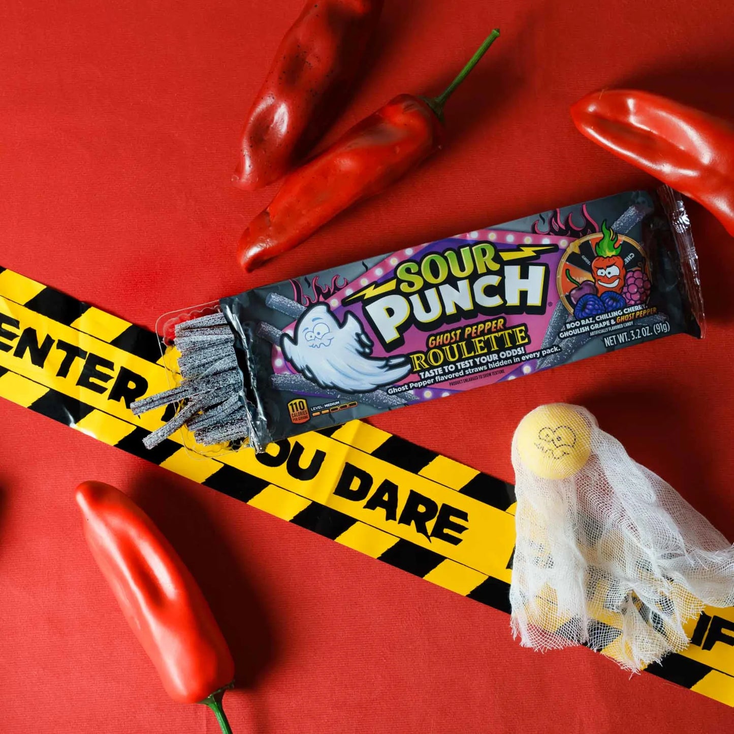 Sour Punch Ghost Pepper Roulette Novelty Candy 3.2oz Tray surrounded by caution tape and peppers