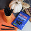 Red Vines Sugar Free Black Licorice Twists in an orange mug near a pumpkin and falltime props