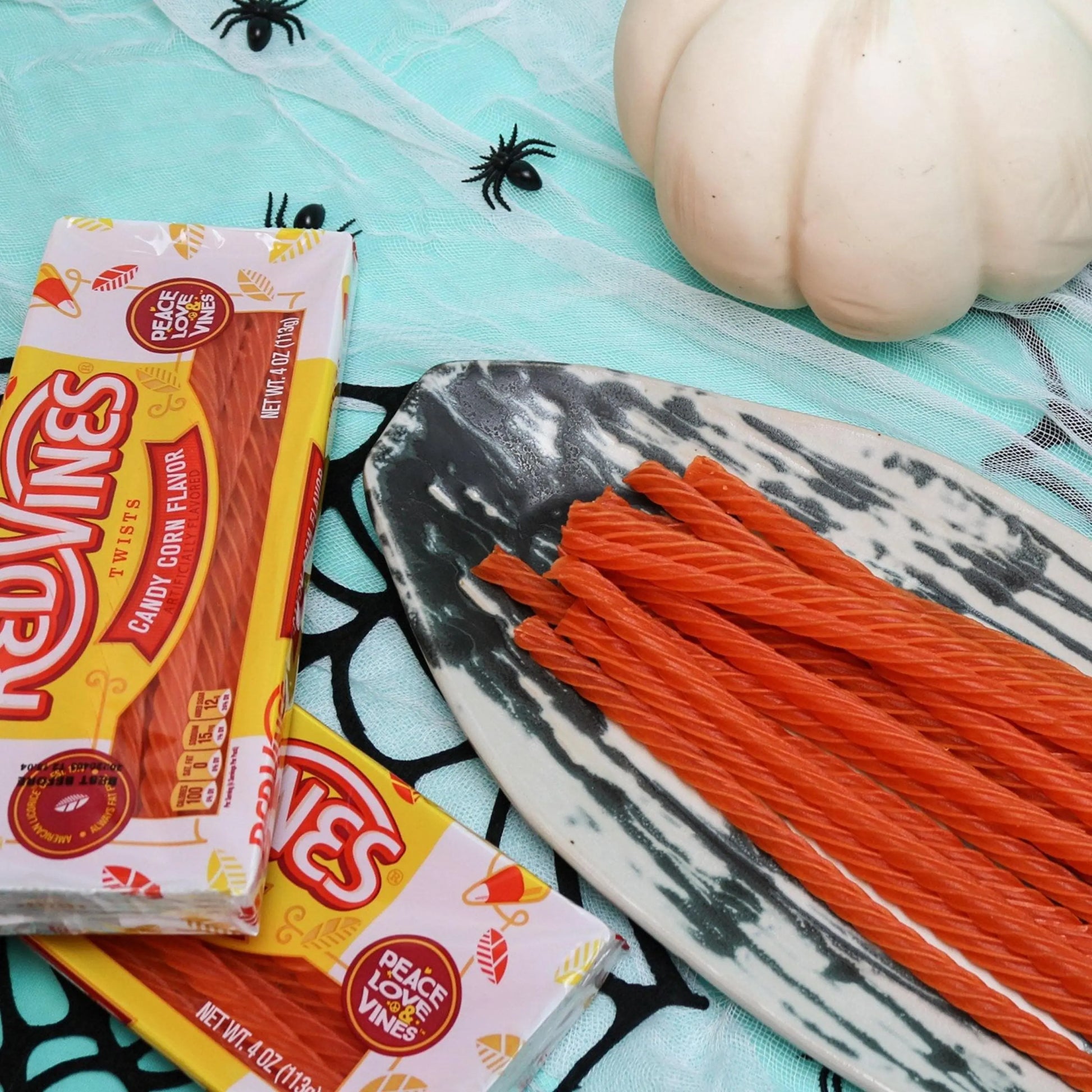 RED VINES Candy Corn Twists, 4oz Tray with orange candy twists on a spooky plate