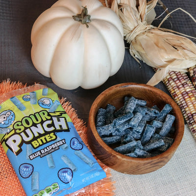 Sour Punch Blue Raspberry Bites Candy in a wooden dish near a pumpkin and falltime props