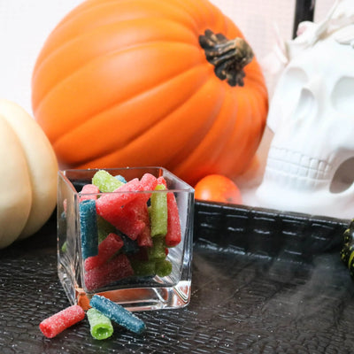 Sour Punch Assorted Bites Candy on a black tray with pumpkins and fake skulls