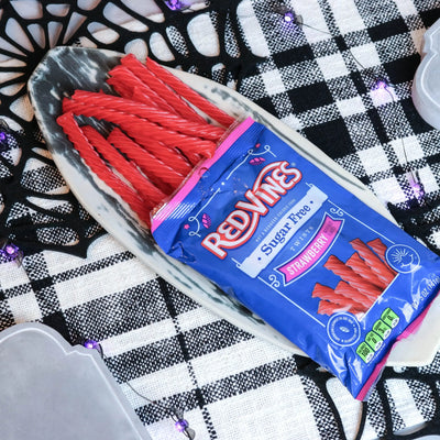 Red Vines Strawberry Sugar Free Licorice on a platter with a fake spiderweb and tombstone