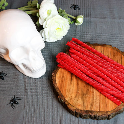 Red Vines Original Red Licorice Candy in a spooky Halloween scene with fake spiders, a white skull and white roses