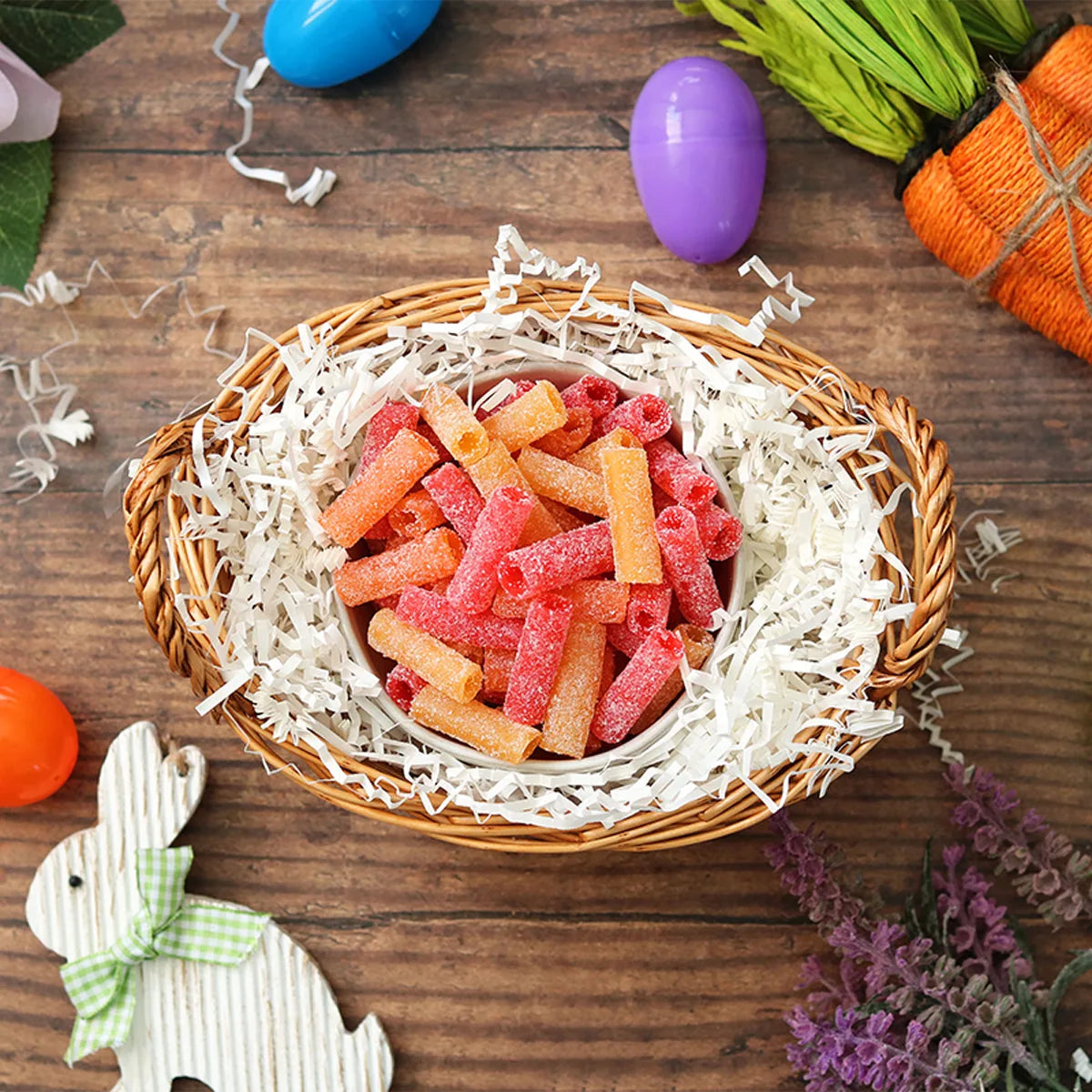 Sour Punch Tropical Bites in an Easter basket  surrounded by confetti and plastic eggs