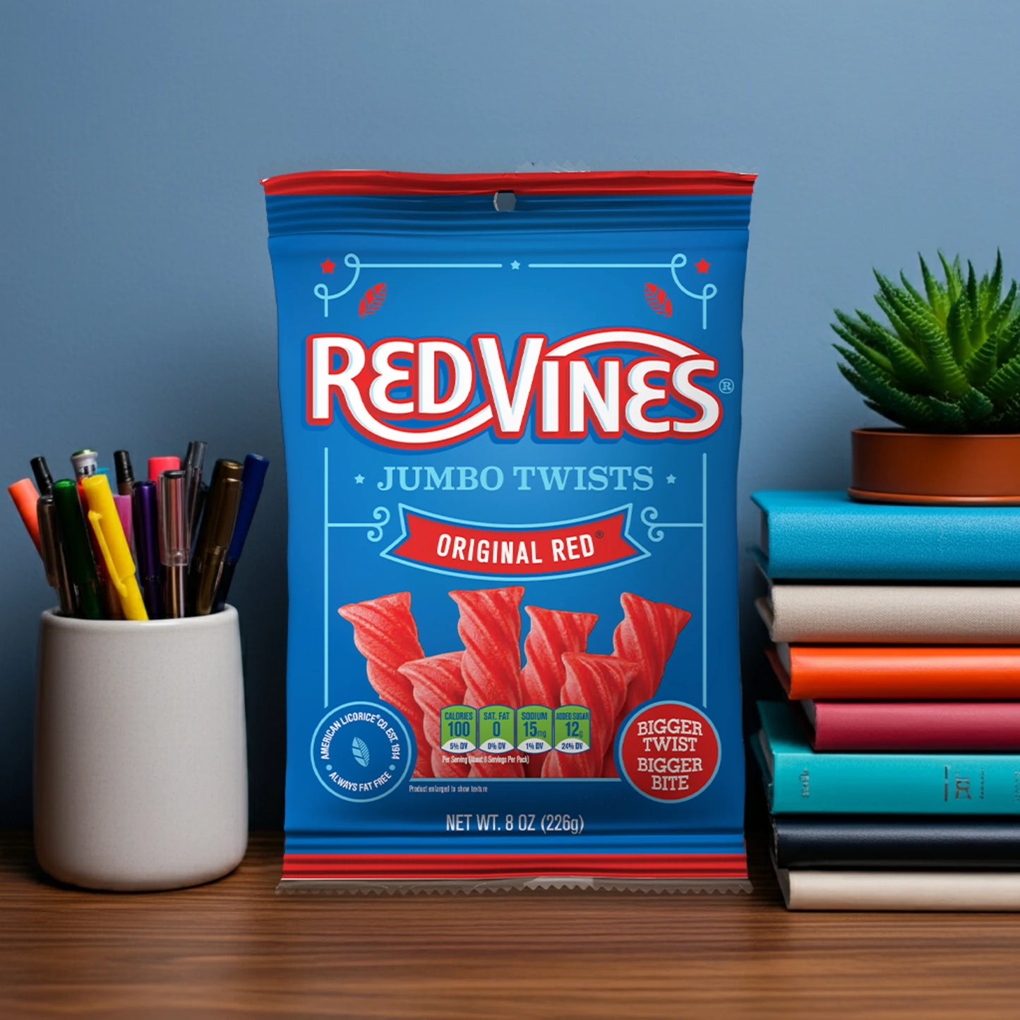 Red Vines Jumbo Twists bag on a desk next to pens and books