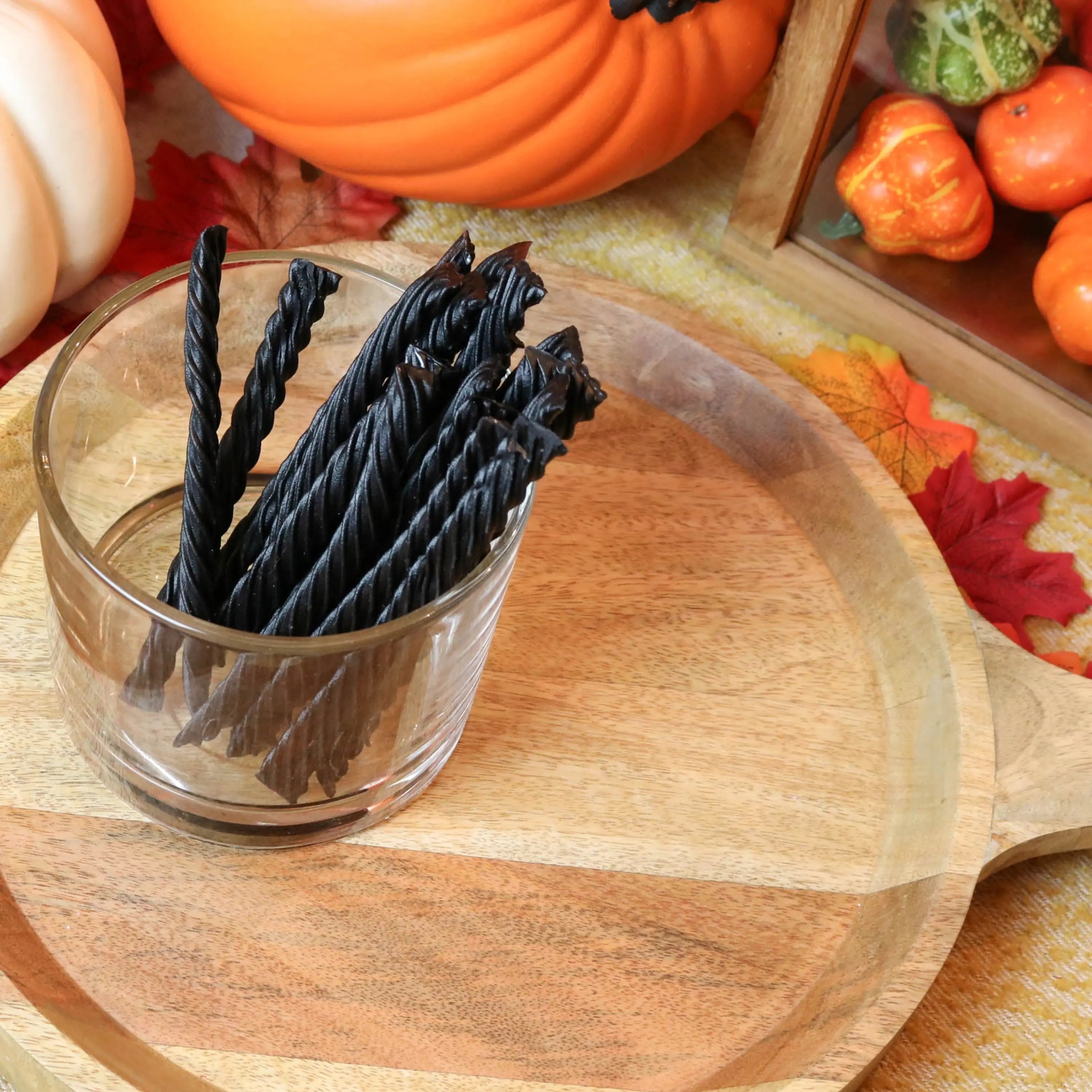 Red Vines Black Licorice Candy in a candy dish surrounded by pumpkins and leaves