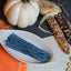 Sour Punch Blue Raspberry Straws Candy in a white dish near a pumpkin and falltime props