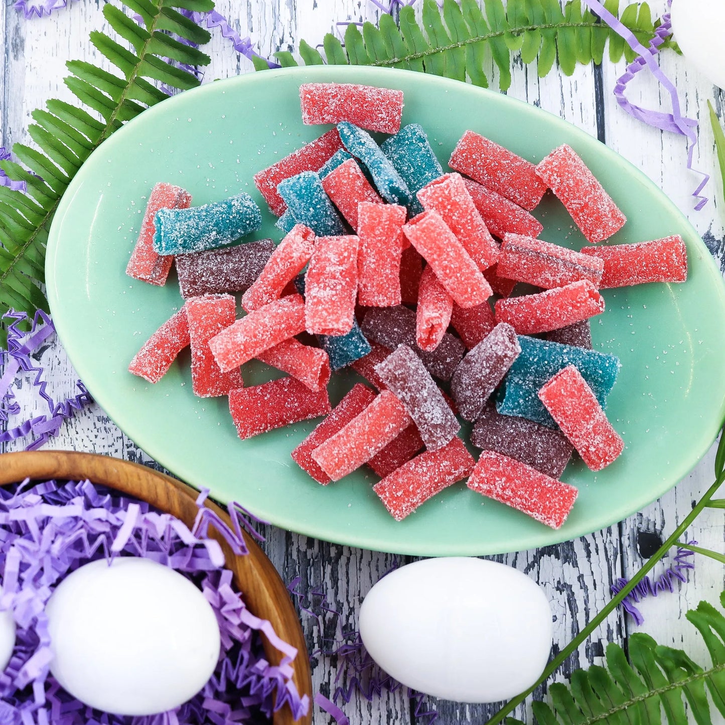 Sour Punch Sweet Bites candy on a picnic table with eggs and confetti