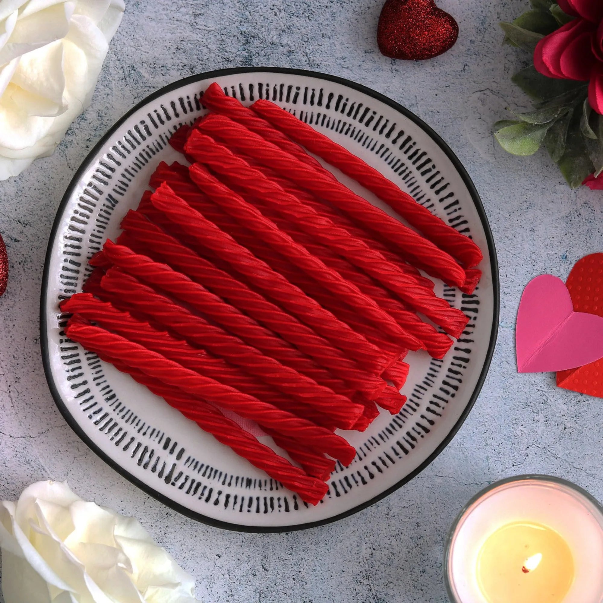 RED VINES Original Red Licorice Twists on a plate surrounded by valentine decor