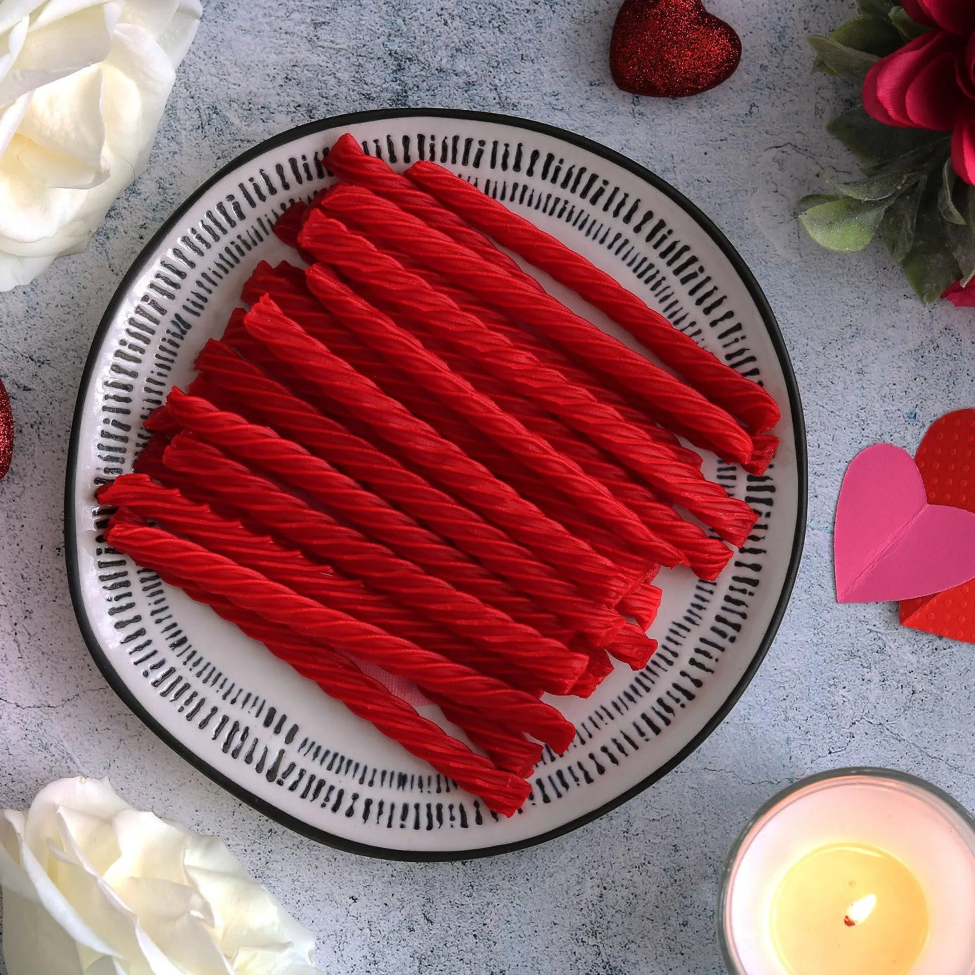 RED VINES Original Red Licorice Twists on a plate surrounded by valentine decor