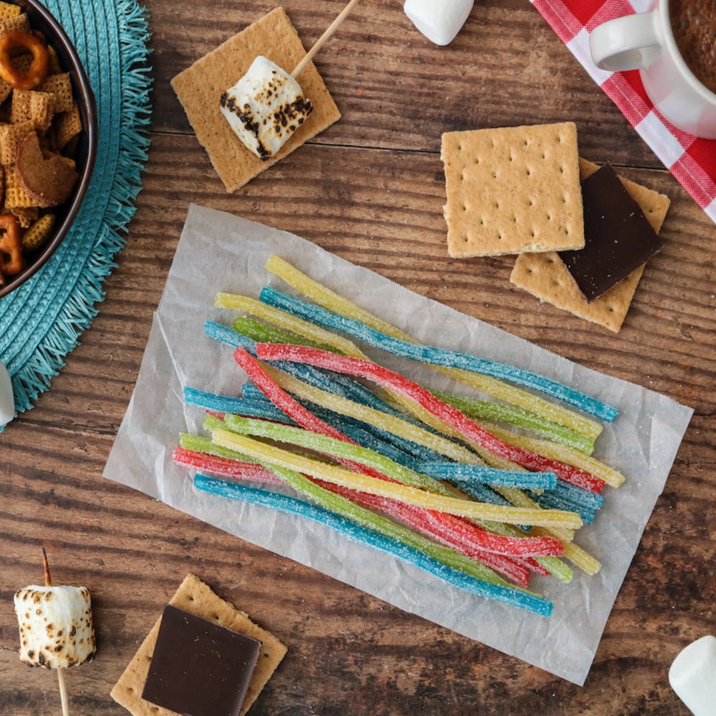 Sour Punch Rainbow Sour Candy Straws alongside s'mores supplies