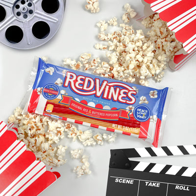 Red Vines Buttered Popcorn & Original Red Twists with fresh popcorn, movie film reel, and Hollywood clapboard