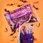A bag of Red Vines Soft & Chewy Twists candy is shown floating above a purple skull-shaped container filled with assorted Red Vines lollipops, set against an orange background with scattered Halloween bat decorations.