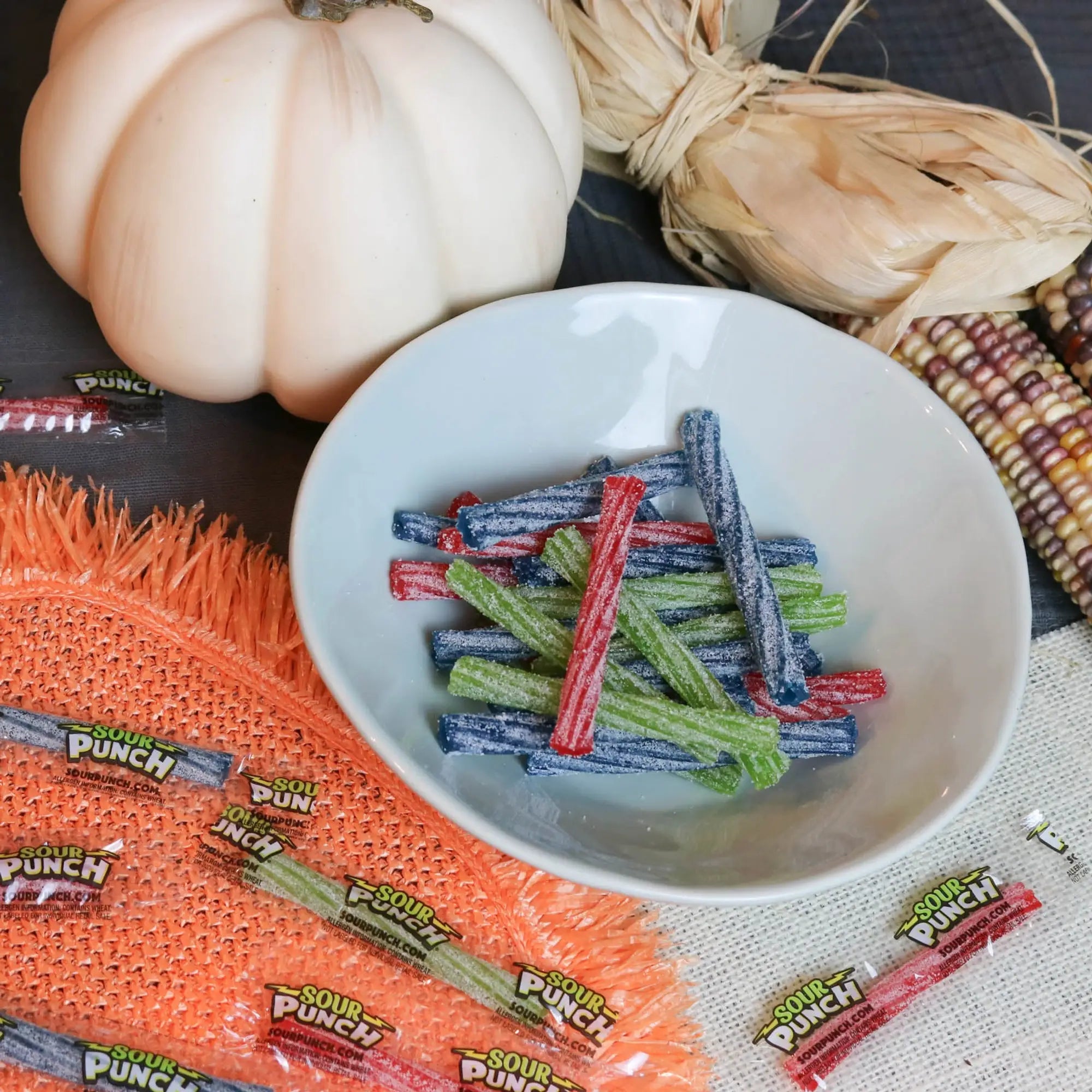 Sour Punch Individually Wrapped 3in Twists Assorted Candy in a white dish near a pumpkin and falltime props