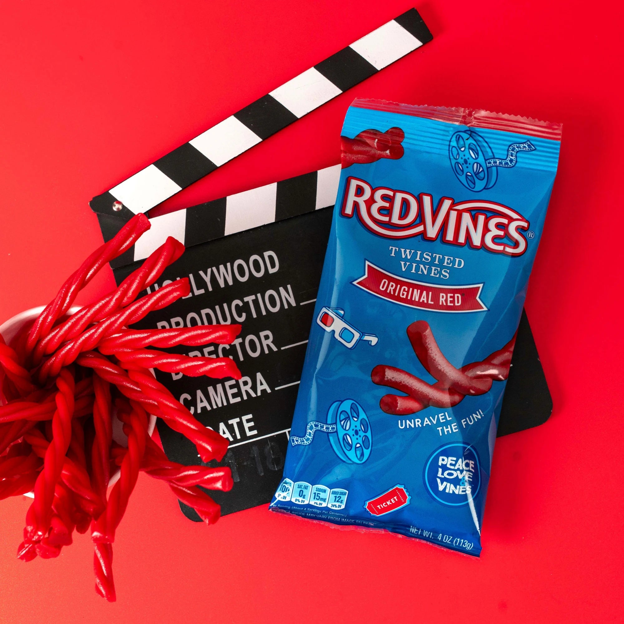Red Vines Original Red Twisted Vines Candy 4oz Bag with raw twisted licorice candy pieces and a film clapper