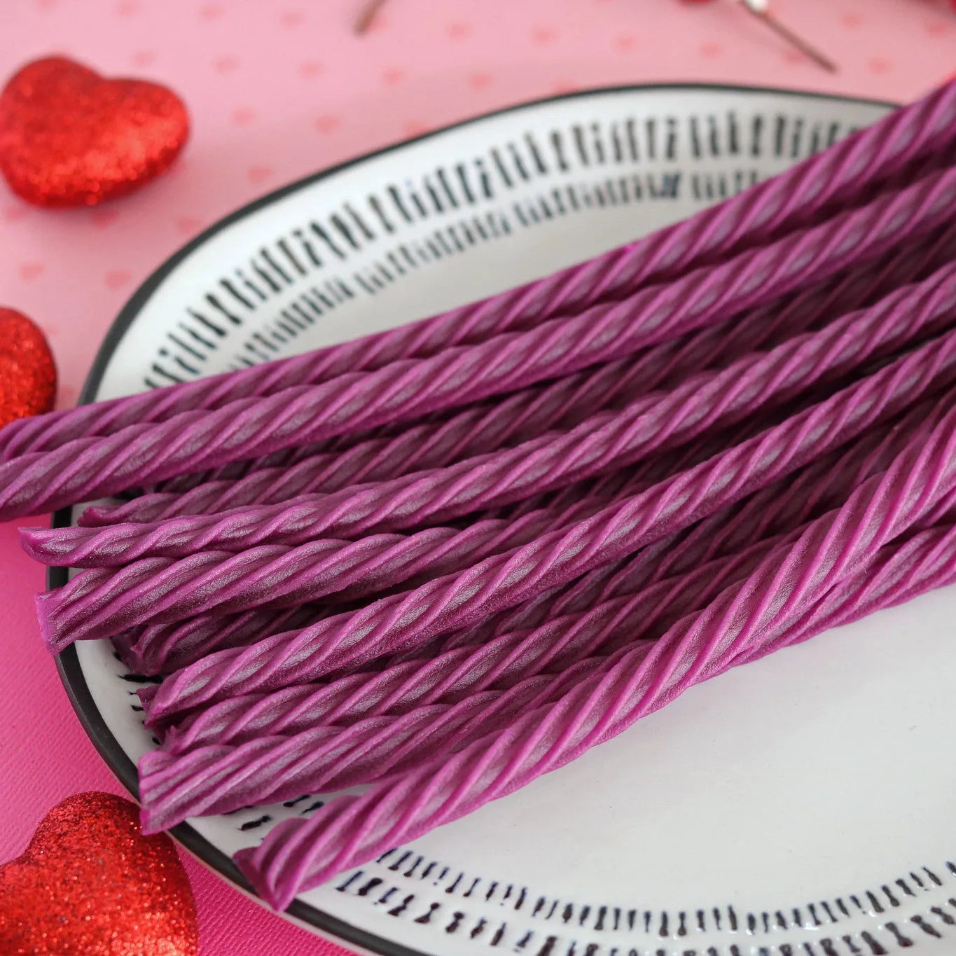 RED VINES Grape Licorice Twists on a white plate surrounded by red sparkle hearts