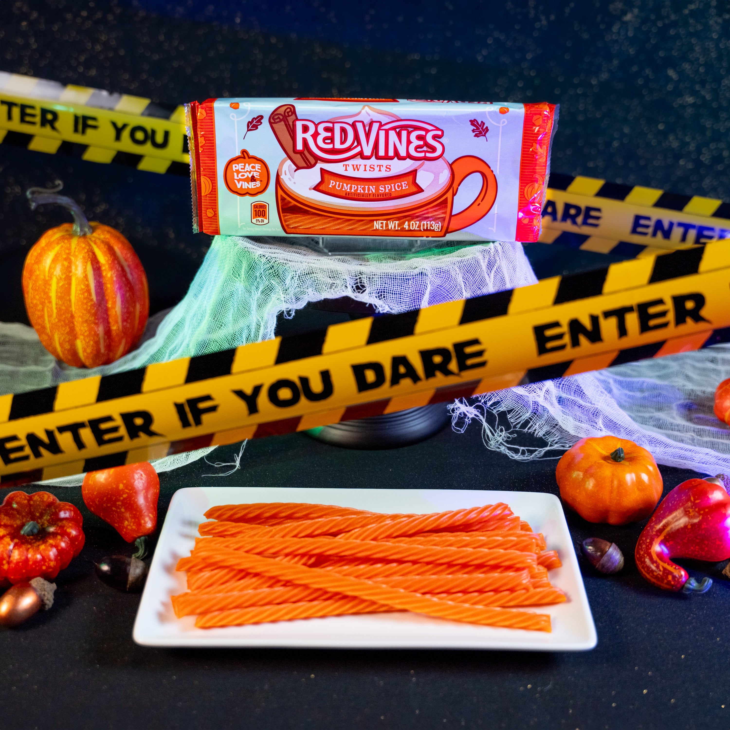 RED VINES Pumpkin Spice Halloween Candy Twists surrounded by pumpkins and caution tape