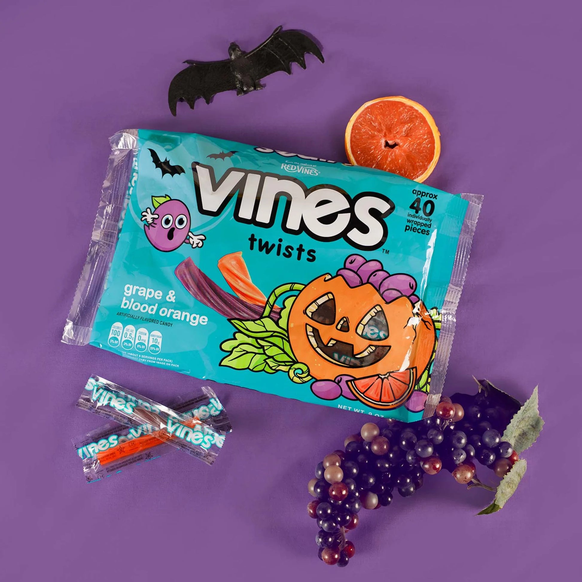 Vines Individually Wrapped Halloween Candy Twists 9oz bag on a purple background with bats and fall fruits