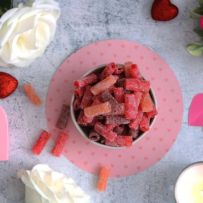 SOUR PUNCH Rad Reds Candy Bites in a bowl surrounded by hearts and roses