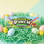 Sour Punch Easter Straws on grass-colored confetti, surrounded by dyed eggs and little chick toys