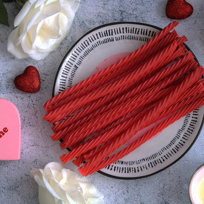 RED VINES Sugar Free Strawberry Licorice Twists on a plate surrounded by white roses and heart decor