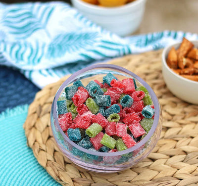 Bowl of Sour Punch Assorted Mini candy on a beach blanket with other salty snacks