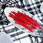 Red Ropes Licorice Rope Candy on a gray serving tray on a platter with a fake spiderweb and tombstone