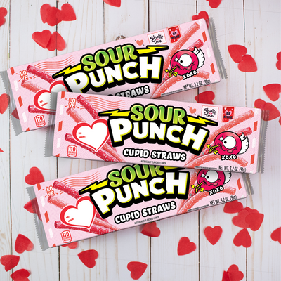 SOUR PUNCH Cupid Straws valentine candy trays on red tablecloth with valentine beads