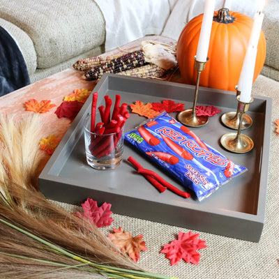 Red Ropes Licorice Rope Candy on a gray serving tray surrounded by falltime props